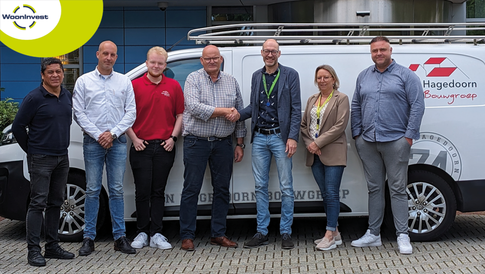 Medewerkers van WoonInvest en Coen Hagedoorn voor een bestelbus.